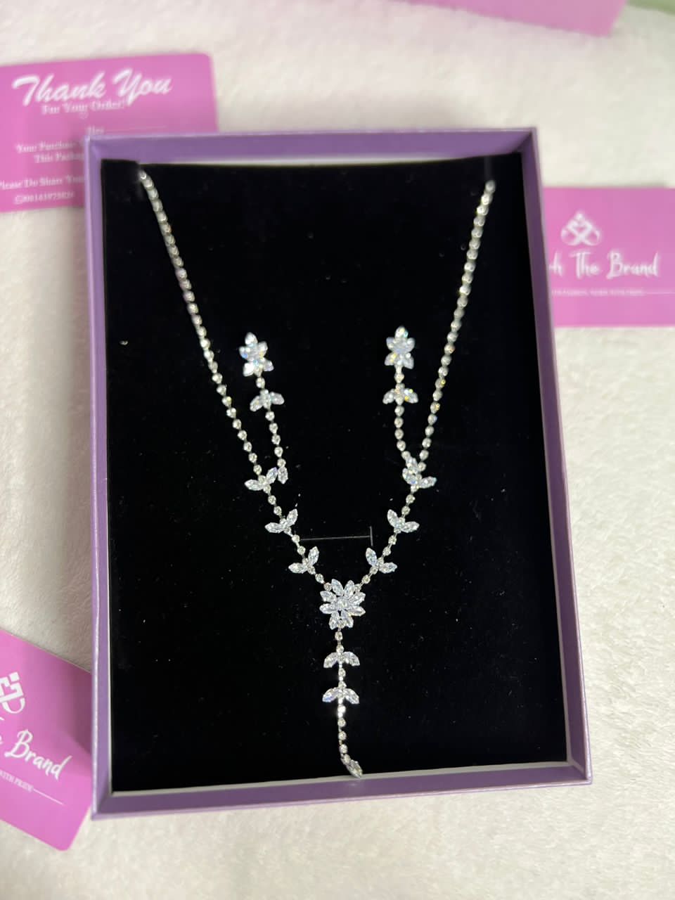 This is a necklace with a floral design featuring diamond-like stones