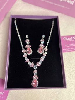 The set features pink and clear stones in a teardrop and oval design