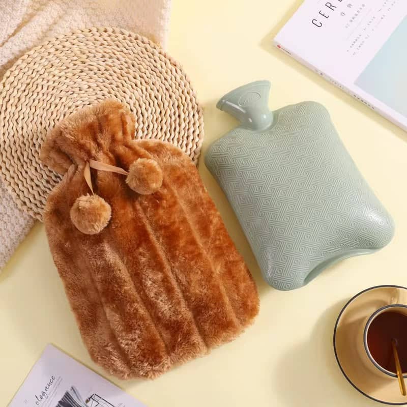A rubber hot water bottle alongside a plush, fluffy faux-fur cover in a warm brown color
