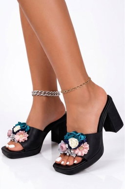 Black slip-on platform mule sandals chunky heel with prominent floral embellishments.