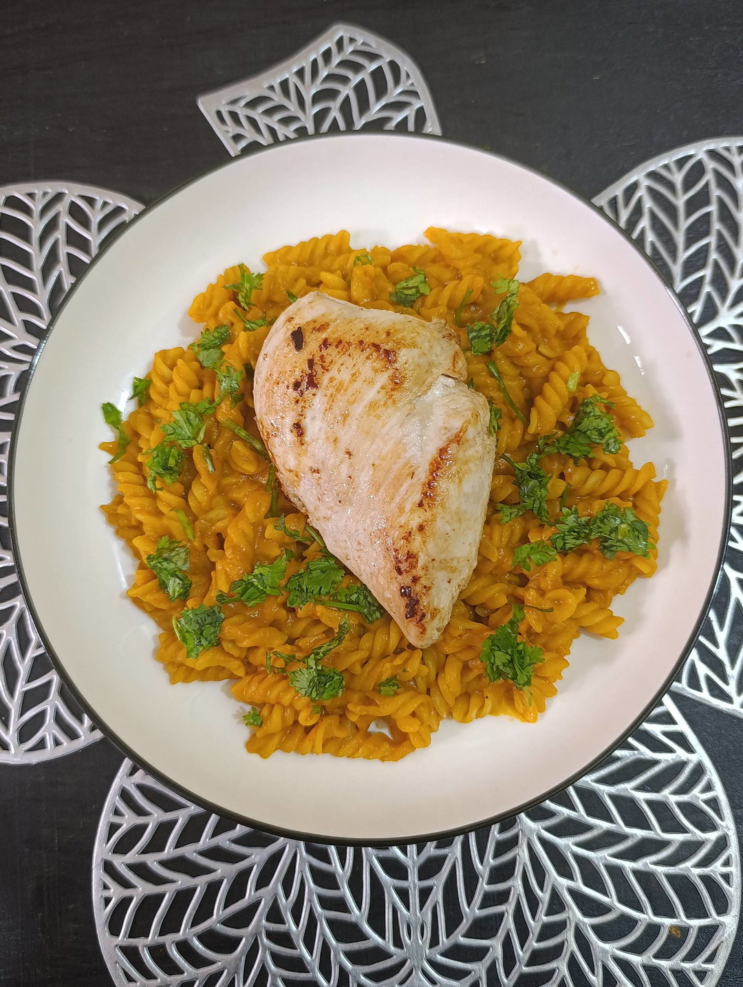 Butter seared chicken breast over creamy tomato pasta